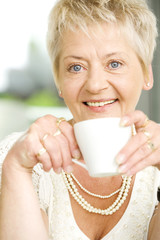 Senior woman sitting at the table in her home