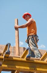 Smiling construction worker with formwork beam