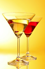 glasses with alcoholic beverage on  yellow-brown background