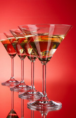 Four martini glasses on red background