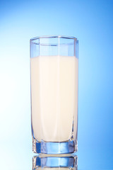 Glass with milk on blue background