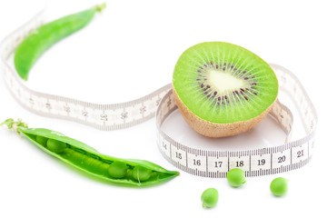 peas,kiwi and measure tape isolated on white