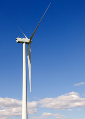 white wind turbine generating electricity on blue sky