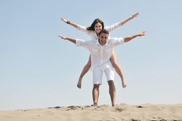 Obraz premium happy young couple have fun on beach