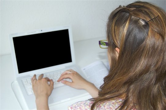 Jeune fille tapant sur un clavier d'ordinateur pour réviser