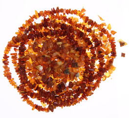 Stones of amber and a necklace on white background
