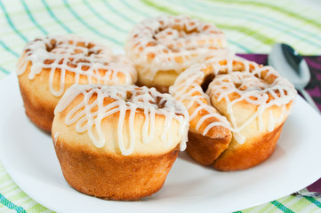 Four rolled muffins with cinnamon and glaze