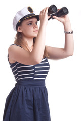 A girl in a sailor cap looks through binoculars