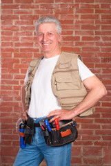 senior builder on wall background