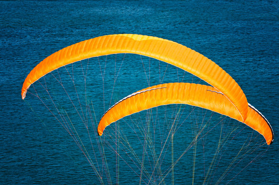 Deux voiles jaunes de parapentes seules sur fond bleu