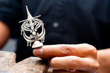 Crafter Hand Holding a traditional Wau Bulan Kite Silver Filligr