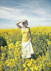 Young woman relaxing on a gold meadow - obrazy, fototapety, plakaty