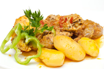 Chicken and potatoes cooked in tomato sauce isolated on white
