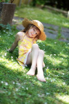 Mädchen mit Strohhut sitzt im Gras  :-)