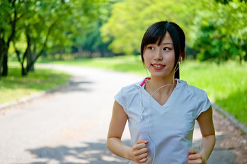 Naklejka premium beautiful asian woman jogging in the park
