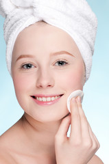 Close-up face of young woman applying sponge