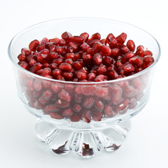 Slices of pomegranate fall into a glass