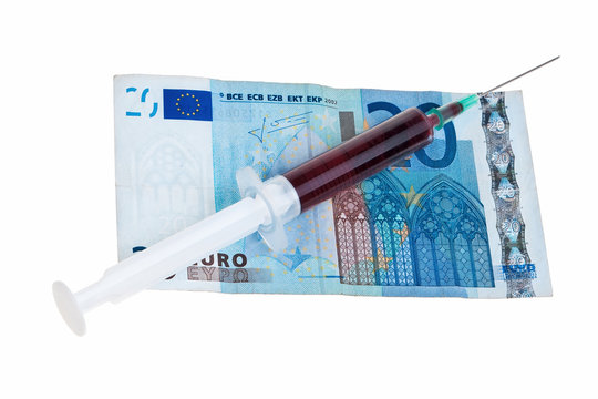 Syringe with red liquid on 20 Euro banknote.