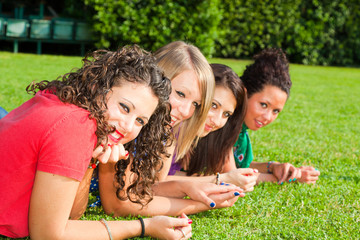 Fototapeta premium Teenage Female Friends Lying on Green at Park