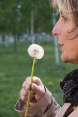 mature woman with dandelion vertical