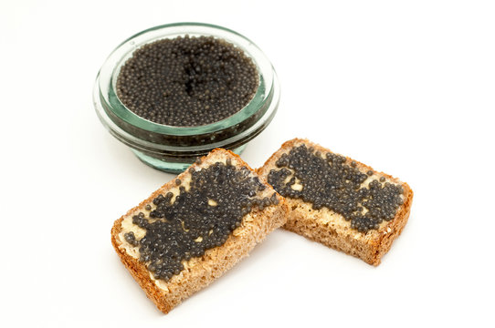 Black caviar in a jar and bread isolated on white
