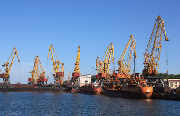 cranes in a port, unloading  ships