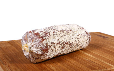 Salami auf Holzbrett mit weissem Hintergrund