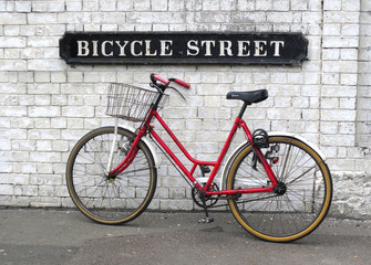 Bicycle Street sign with a red bicycle against wall