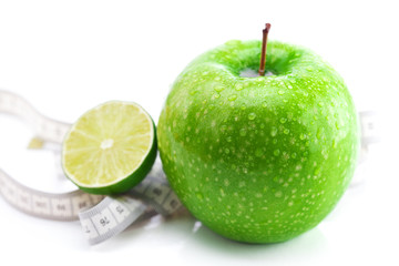 apple,lime and measure tape isolated on white