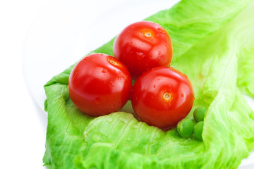 tomato and lettuce on a plate isolated on white