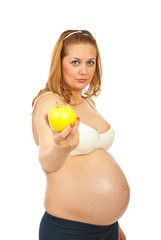 Pregnant woman offering yellow apple