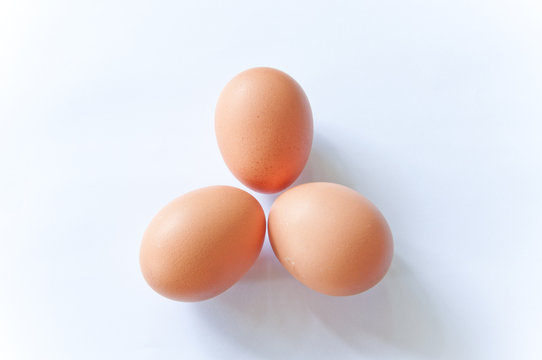 close up three hens eggs on white background