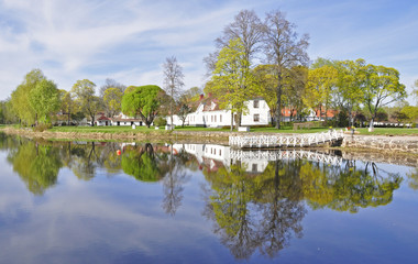 Fototapeta na wymiar Spokój refleksji jezioro dom i drzewa w wodzie