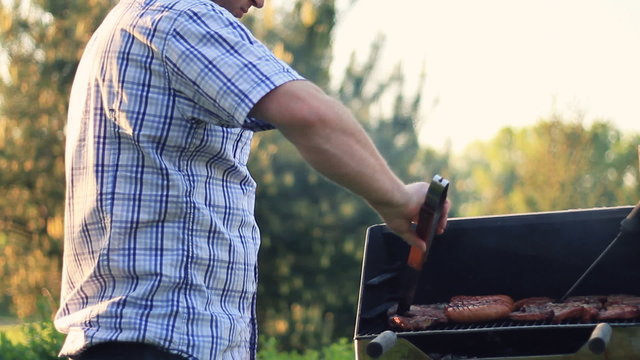 Man cooking meat on the barbecue grill, steadicam shot