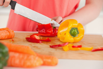 Young woman cutting some vegetables in the kitchen