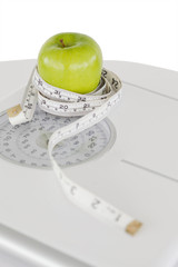 Green apple circled with a tape measure and a weigh-scale