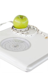 Green apple circled with a tape measure and a weigh-scale