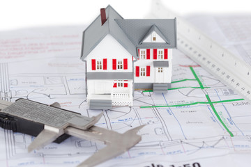 Close-up of toy house model and ruler on a plan