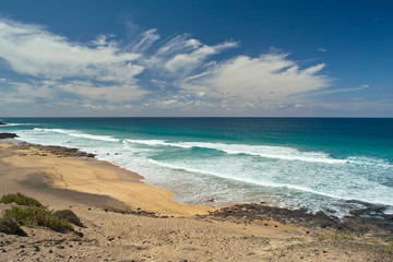 Ocean waves rolls on the footprints on sandy beach