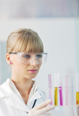 female researcher holding up a test tube in lab