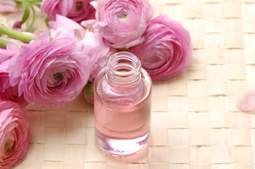 Obraz na płótnie Canvas Perfume bottles with dahlia flower on woven mat