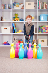 Smiling boy playing kids bowling game