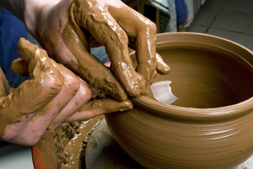 hands of a potter, creating an earthen jar on the circle