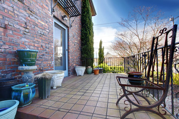 English brick hose deck with pots and iron chairs