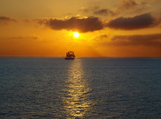 Romantic frigate sailing on sea sunset .