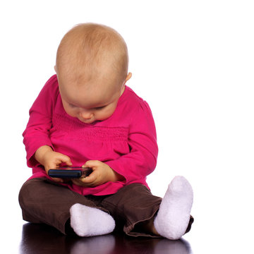 Infant girl playing with a cell phone
