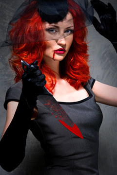 Portrait of a female vampire with bloody knife in hand