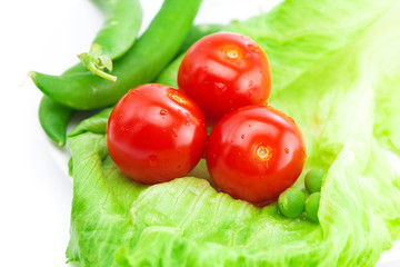 tomato,peas and lettuce on a plate isolated on white