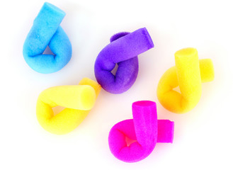 few color hair curlers on a white background