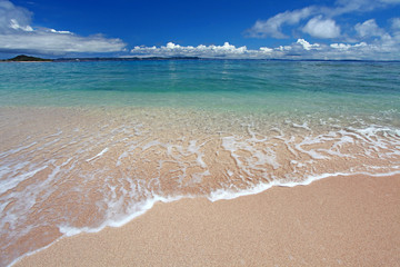 Fototapeta na wymiar 美しい砂浜に打ち寄せる透明な波